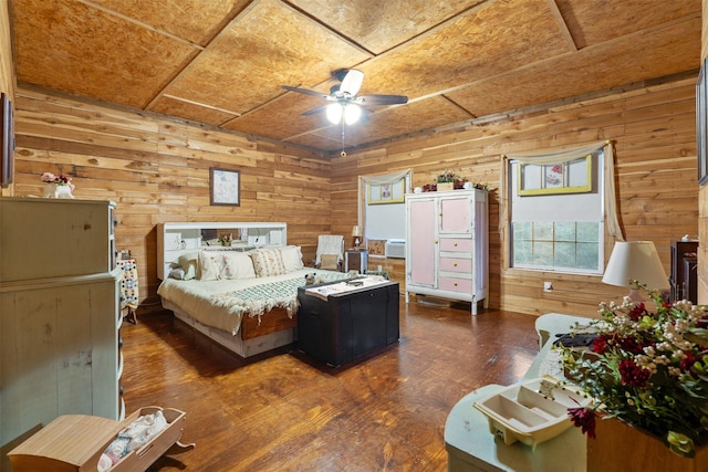 bedroom with dark wood-type flooring, wooden walls, and a ceiling fan