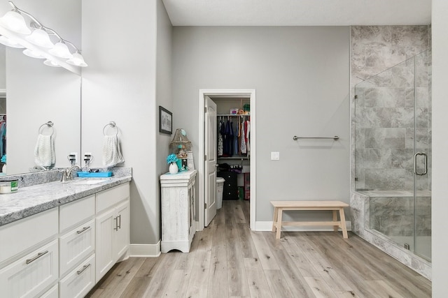 bathroom with a shower with door, vanity, and hardwood / wood-style floors