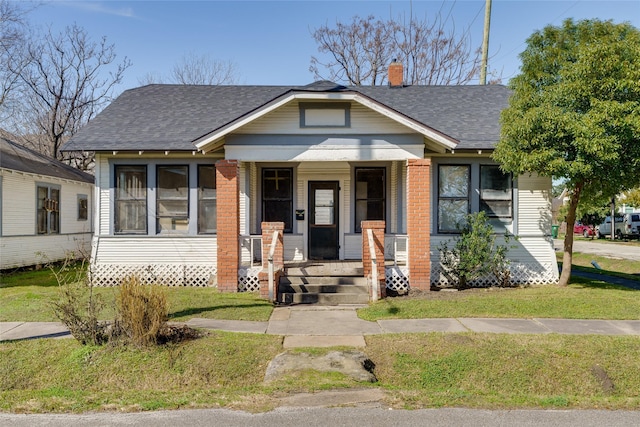 bungalow-style house featuring a porch and a front yard