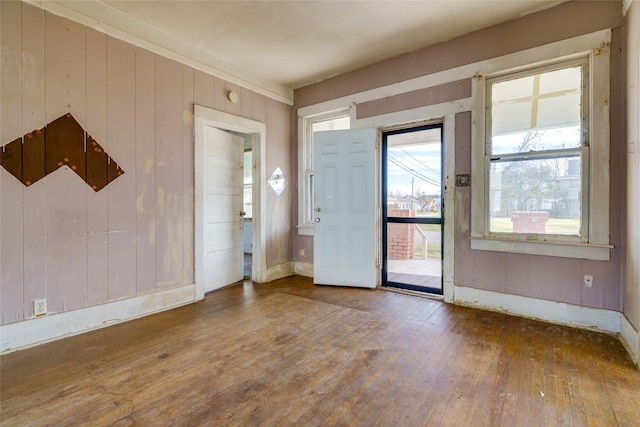 foyer entrance with wood-type flooring and wooden walls