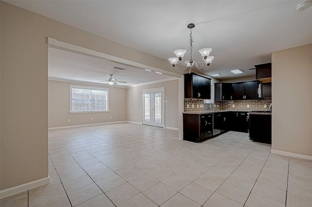 kitchen featuring ceiling fan with notable chandelier, decorative backsplash, light tile patterned floors, light stone counters, and crown molding