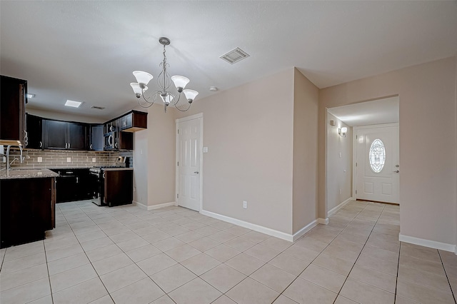 kitchen featuring light tile patterned flooring, appliances with stainless steel finishes, decorative light fixtures, decorative backsplash, and light stone countertops