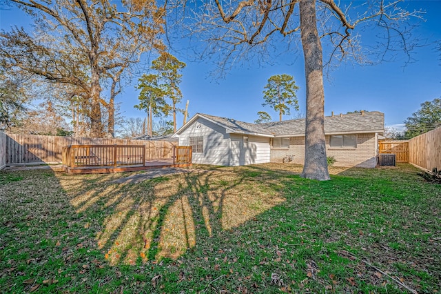 rear view of property with a wooden deck and a yard