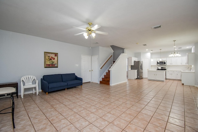 tiled living room featuring sink and ceiling fan with notable chandelier