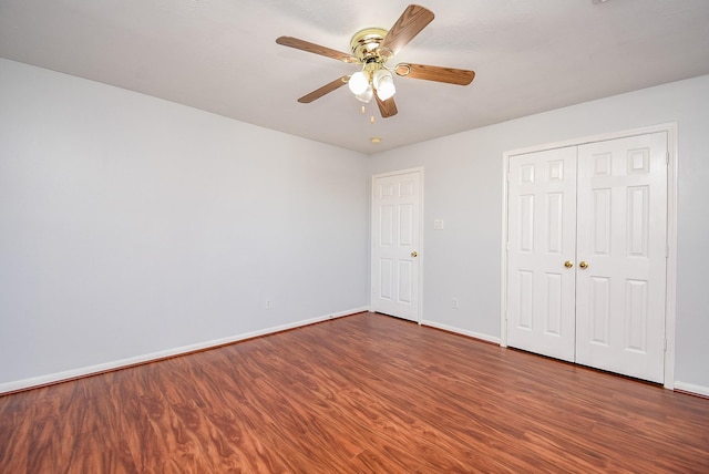 unfurnished bedroom with dark wood-type flooring, ceiling fan, and a closet