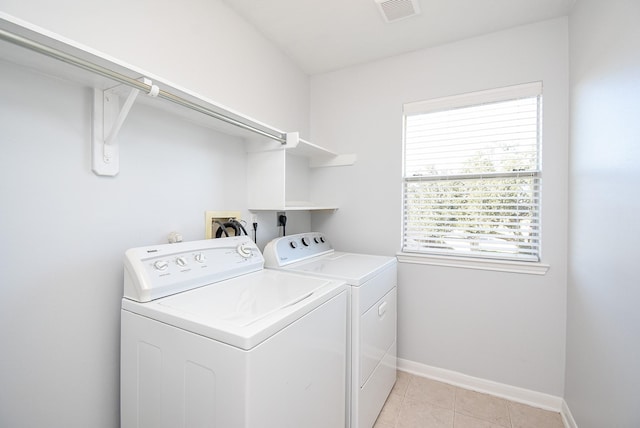 laundry area with washing machine and dryer and light tile patterned flooring