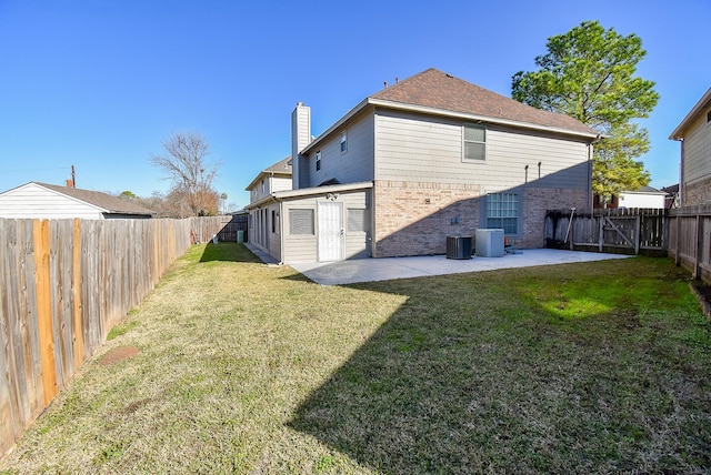 rear view of property featuring cooling unit, a yard, and a patio area