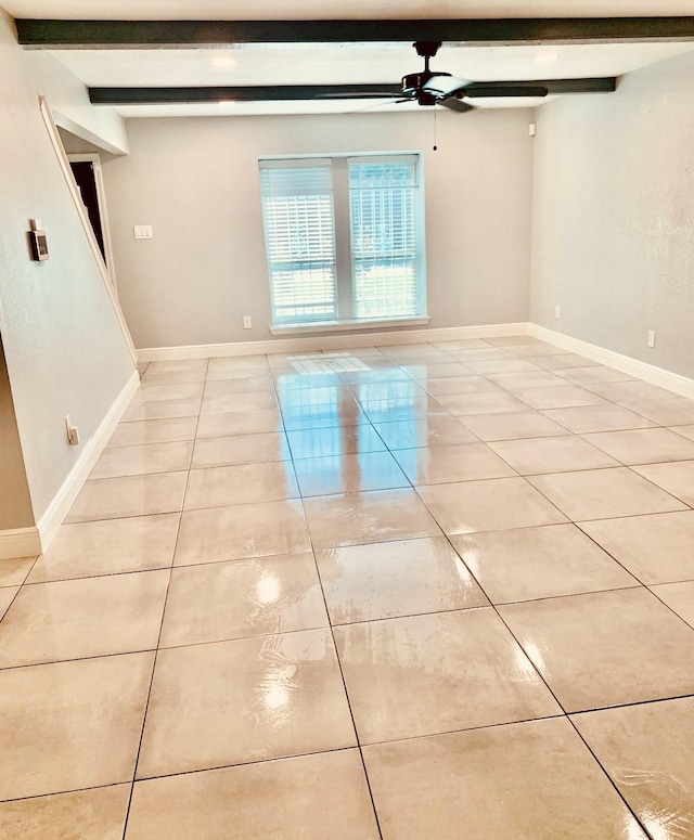 spare room featuring light tile patterned floors, beam ceiling, and ceiling fan