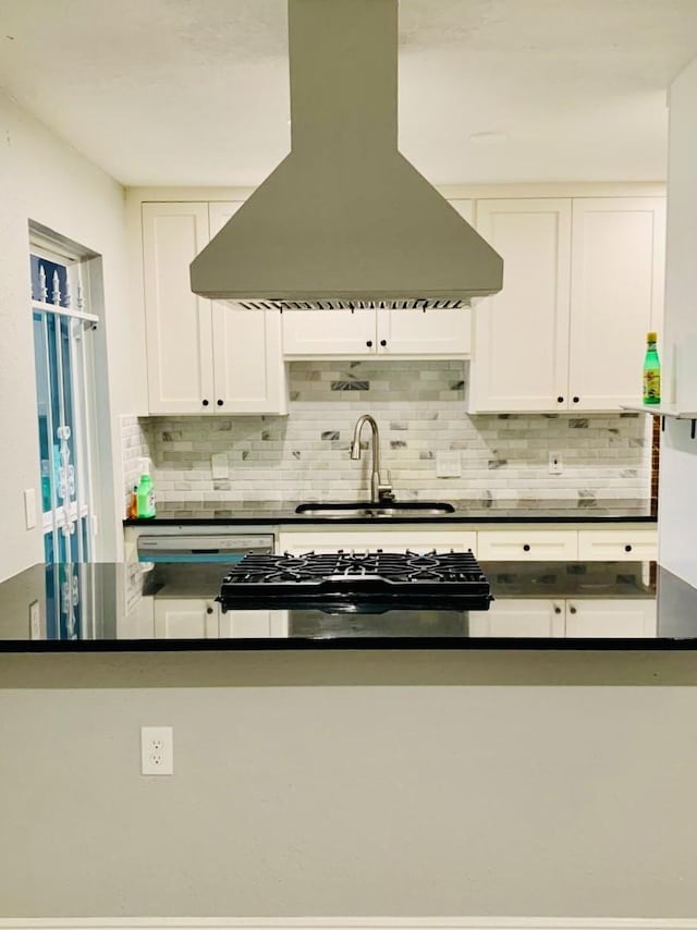 kitchen featuring island range hood, sink, white cabinets, backsplash, and stove