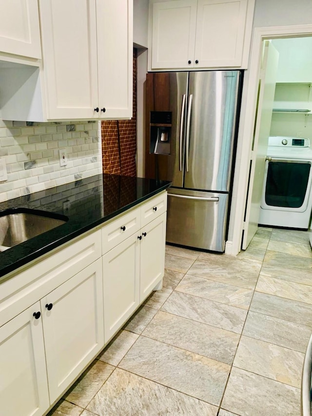 kitchen featuring white cabinetry, dark stone counters, range, and stainless steel fridge with ice dispenser