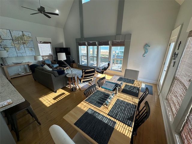 living room with dark hardwood / wood-style flooring, a wealth of natural light, high vaulted ceiling, and ceiling fan