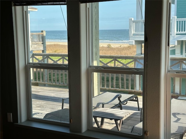 doorway to outside featuring plenty of natural light, a beach view, and a water view