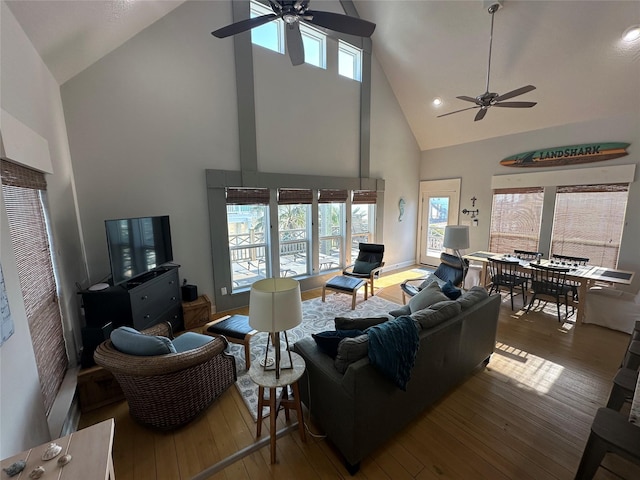 living room with ceiling fan, high vaulted ceiling, and hardwood / wood-style floors