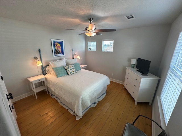 bedroom featuring ceiling fan, a textured ceiling, and light wood-type flooring