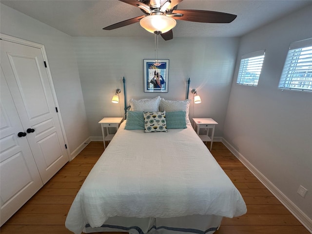 bedroom with ceiling fan, hardwood / wood-style floors, and a textured ceiling