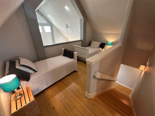 bedroom with lofted ceiling and light hardwood / wood-style flooring