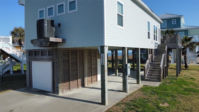 rear view of house featuring a carport, a garage, and central AC unit