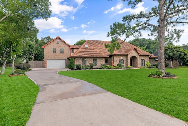 mediterranean / spanish-style home with a garage and a front lawn