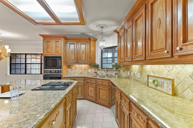 kitchen featuring crown molding, decorative light fixtures, sink, and black appliances