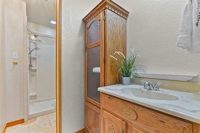 bathroom featuring vanity, tile patterned flooring, and tiled shower