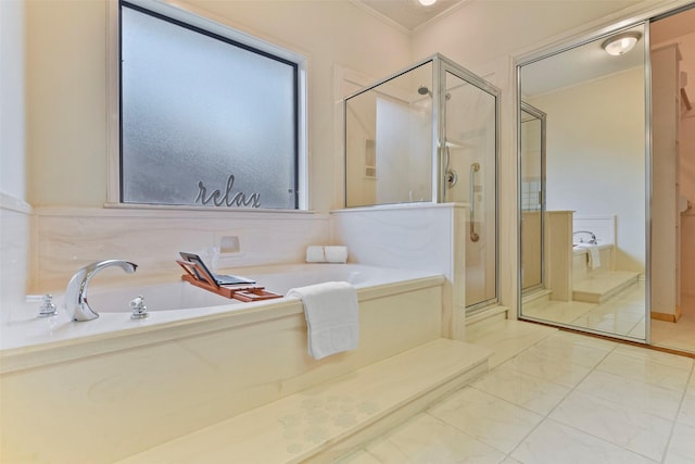 bathroom with ornamental molding and shower with separate bathtub