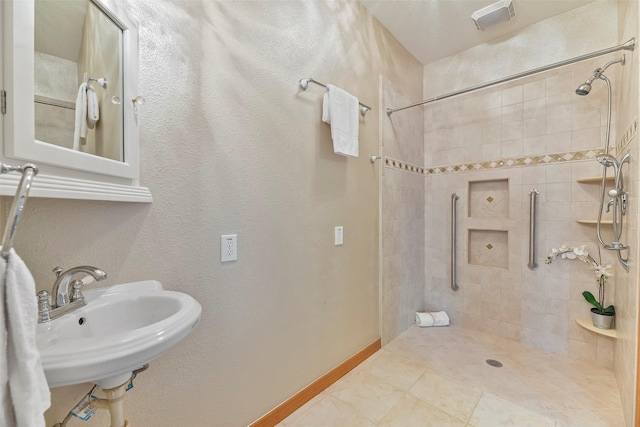 bathroom featuring sink and tiled shower