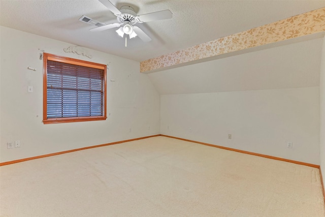 bonus room featuring ceiling fan, vaulted ceiling, a textured ceiling, and carpet