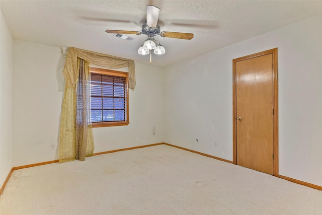 carpeted spare room with ceiling fan and a textured ceiling