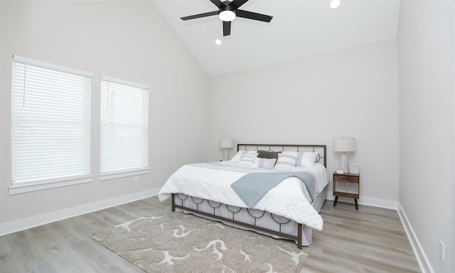 bedroom with ceiling fan, high vaulted ceiling, and light wood-type flooring