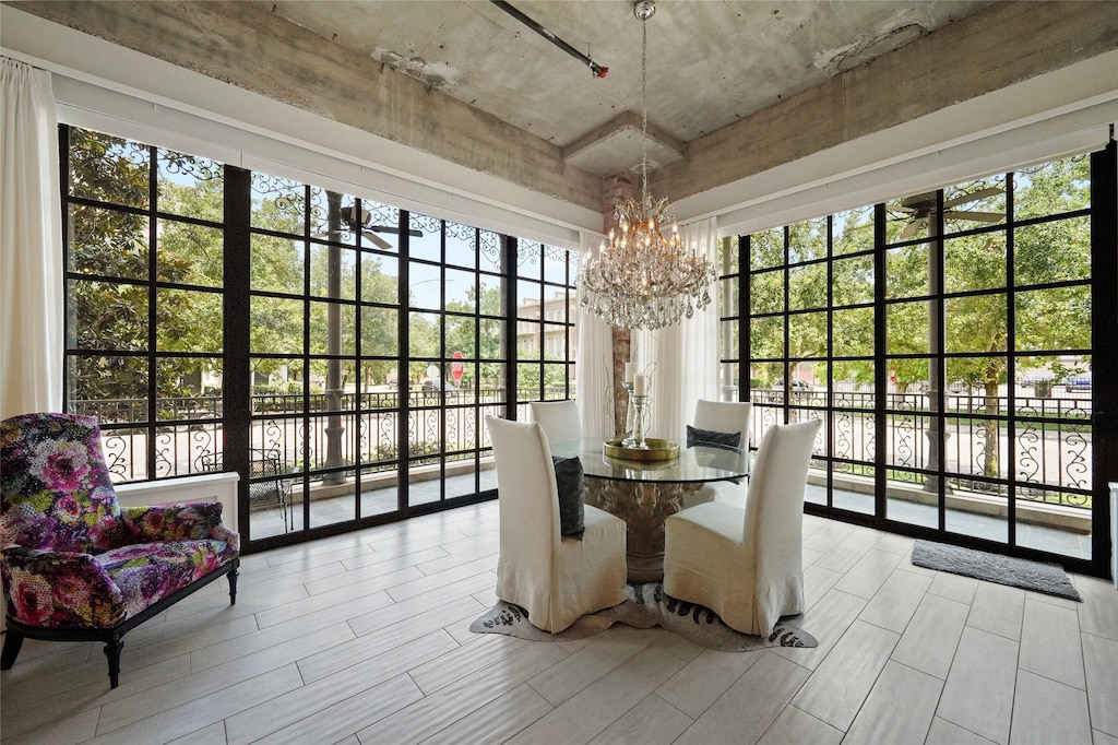 dining area with a notable chandelier, plenty of natural light, and a wall of windows