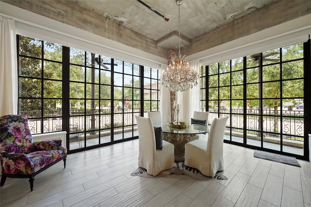 dining area with a notable chandelier, plenty of natural light, and a wall of windows