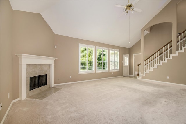 unfurnished living room featuring ceiling fan, a fireplace, high vaulted ceiling, and light carpet