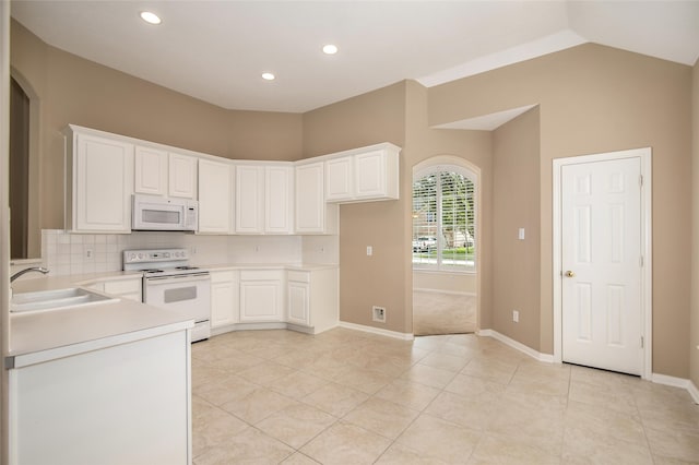 kitchen featuring white cabinetry, sink, decorative backsplash, light tile patterned floors, and white appliances