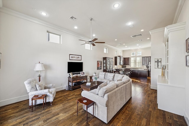 living room featuring dark wood-type flooring, ornamental molding, and ceiling fan