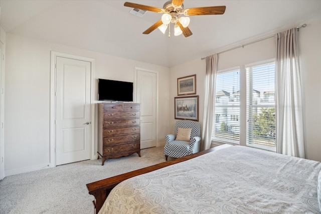 bedroom featuring light carpet, multiple windows, ceiling fan, and vaulted ceiling