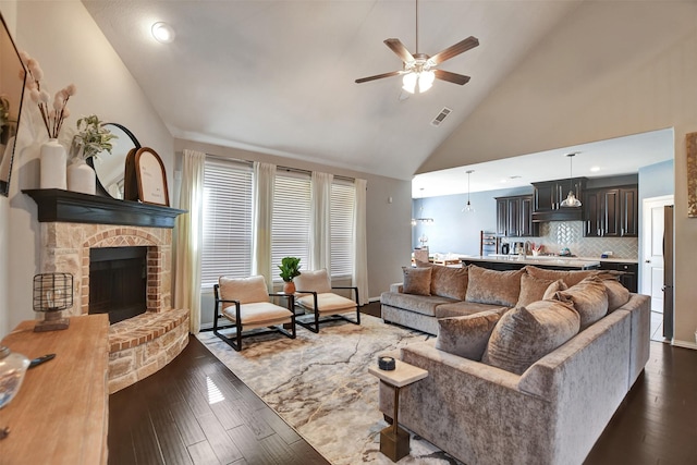 living room with ceiling fan, high vaulted ceiling, dark hardwood / wood-style floors, and a fireplace