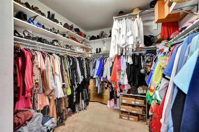 walk in closet featuring light colored carpet