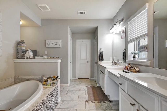 bathroom with vanity and tiled bath