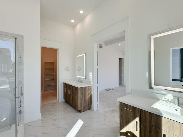 bathroom with a high ceiling, vanity, and a shower with shower door