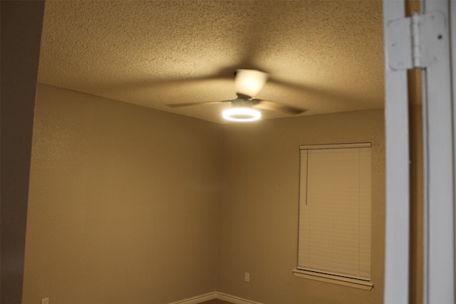 spare room featuring a textured ceiling and ceiling fan