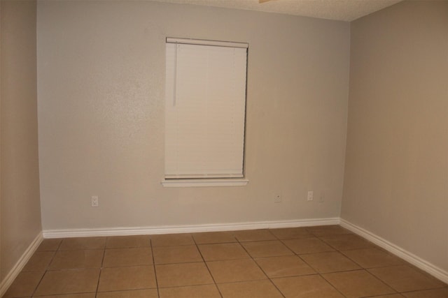 empty room featuring tile patterned floors and a textured ceiling