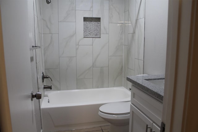 full bathroom with tiled shower / bath, vanity, and toilet