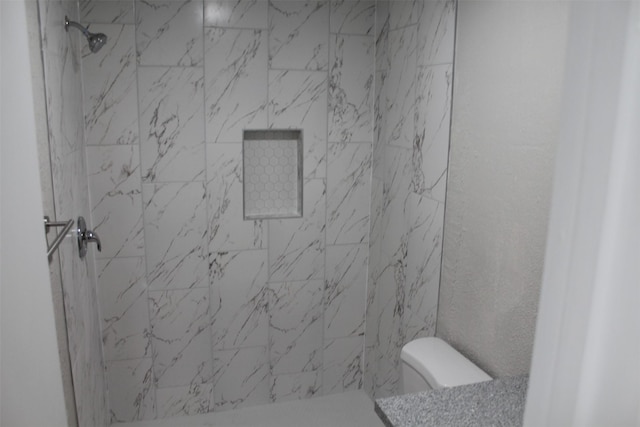 bathroom with toilet and tiled shower