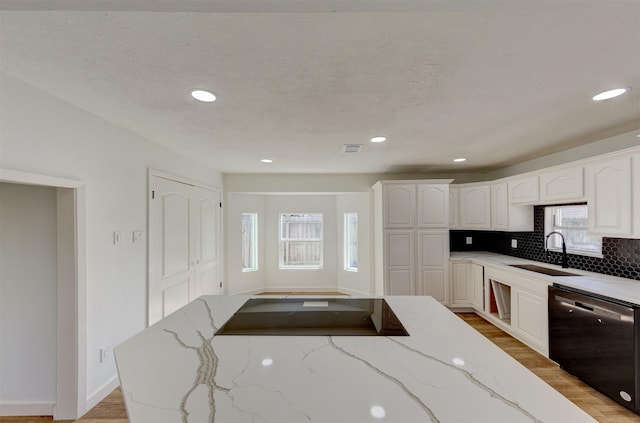 kitchen featuring sink, light stone countertops, white cabinets, and dishwasher