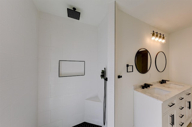 bathroom featuring a tile shower and vanity