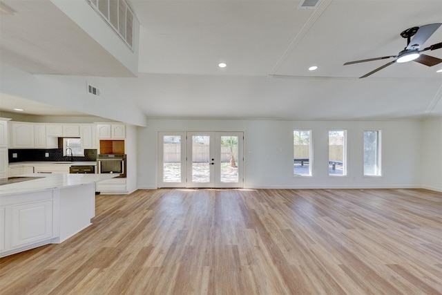 unfurnished living room with light hardwood / wood-style flooring, french doors, and ceiling fan