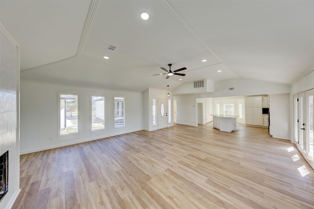 unfurnished living room featuring a fireplace, light hardwood / wood-style floors, and vaulted ceiling