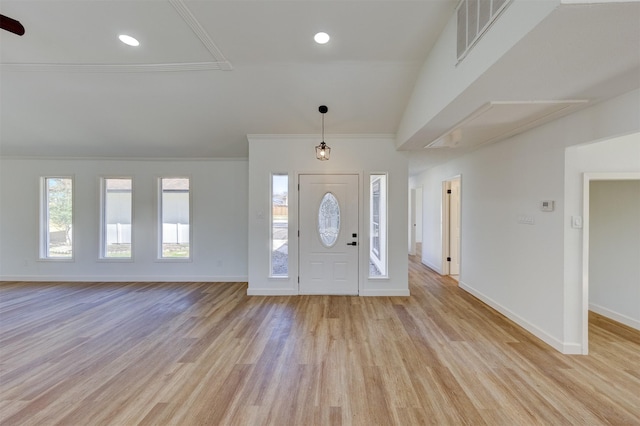 foyer with ornamental molding, a healthy amount of sunlight, and light hardwood / wood-style flooring