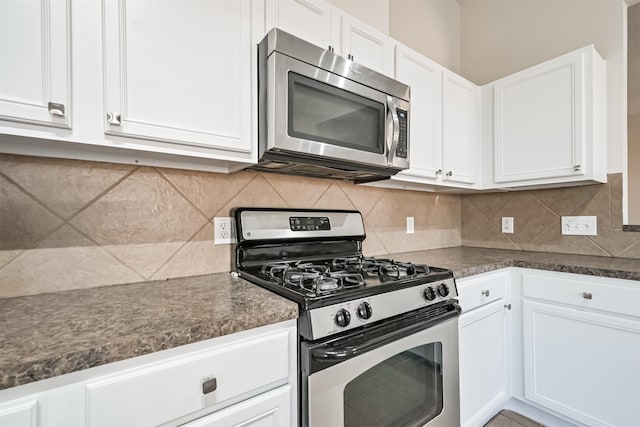 kitchen with decorative backsplash, white cabinets, and appliances with stainless steel finishes