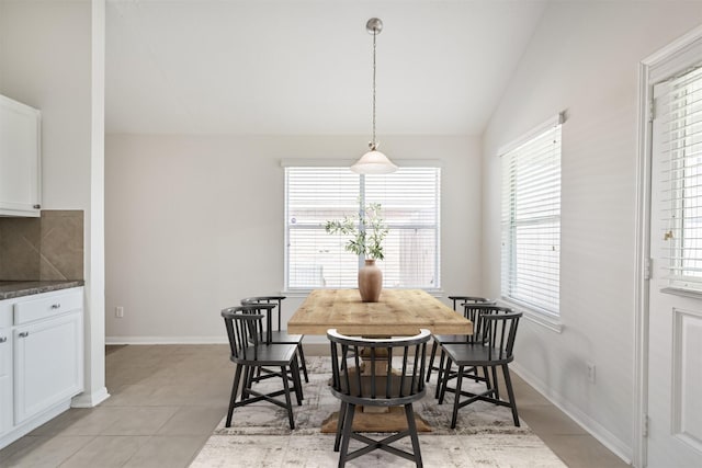 tiled dining space featuring lofted ceiling